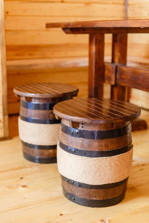 Wooden barrel as a place to sit at a table in the room. Wooden furniture.