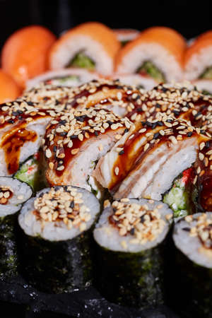 Close up of appetizing sushi with tuna, soy sauce and sesame and maki rolls.の写真素材