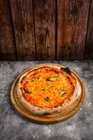 Classic homemade Italian cheese pizza fresh out of the oven. Pizza with cheese and basil leaves. The concept of nutritious food.の写真素材