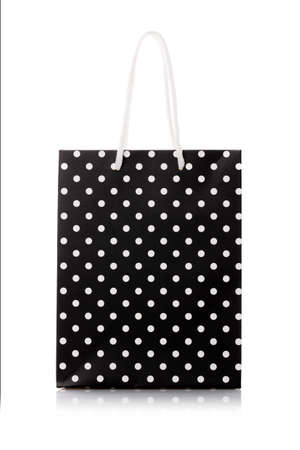 Black package for shopping or gifts with white handles and dots.の写真素材