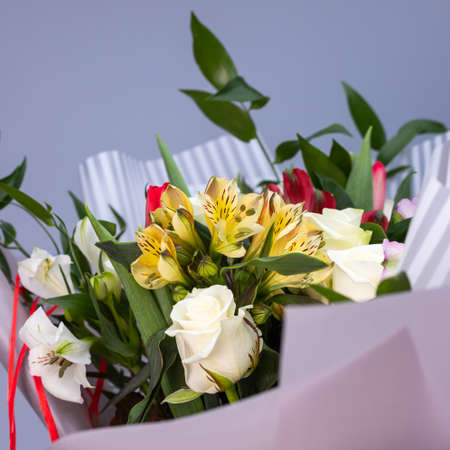 Close up of bright bouquet of colored flowers wrapped in gift paper.の写真素材