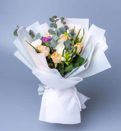 Delicate romantic bouquet of flowers wrapped in white paper.の写真素材
