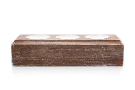 Close up of a wooden candlestick for three small candles on a white background.の写真素材