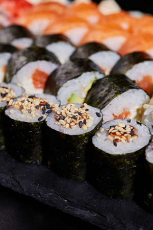 Close up of maki sushi with sesame seeds wrapped in nori leaves.の写真素材
