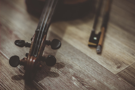 Vintage old violin lying on a wooden surfaceの写真素材