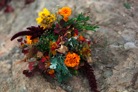 Wedding bouquet in a bright autumn style. On the background of stone rocks. Marigold flowersの写真素材