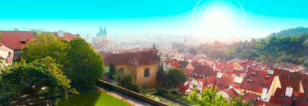 Panorama of Prague in Czech Republic with red roofs, blue sky and green grass. Sunny dayの写真素材