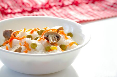 Plate with the rice and the vegetables on the kitchen table の写真素材