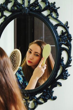 young girl combing her hairの写真素材