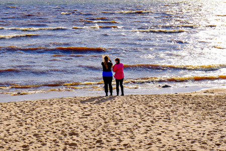 two girls stand on the beachの写真素材