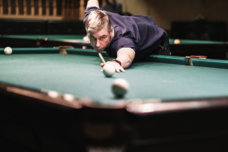 a pool player takes aim at the ballの写真素材