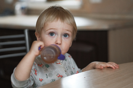 cute baby drinking from a bottleの写真素材