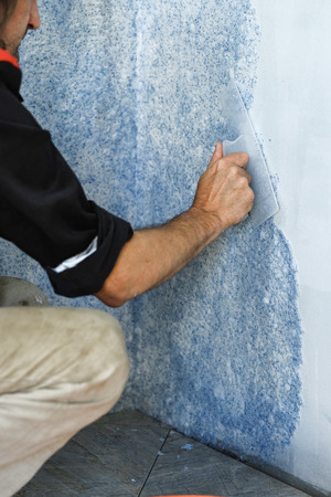 the worker puts liquid Wallpaper on the wallの写真素材