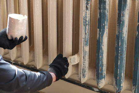 worker paints the metal water heating radiatorの写真素材