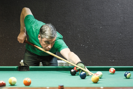 a pool player takes aim at the ballの写真素材