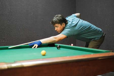 a pool player takes aim at the ballの写真素材