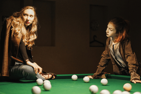 two beautiful girls in the billiard roomの写真素材