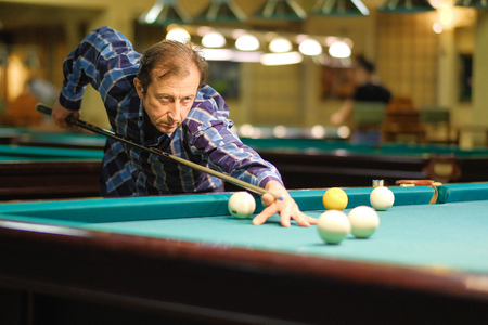 the player takes aim at the ball in Billiardsの写真素材