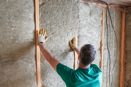 worker insulates a country house of mineral woolの写真素材