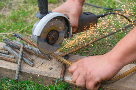 Builder on the construction site cutting metal grinderの写真素材