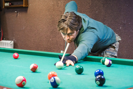 the player takes aim at the ball in Billiards
