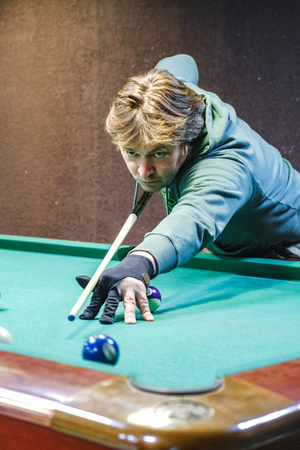 the player takes aim at the ball in Billiards