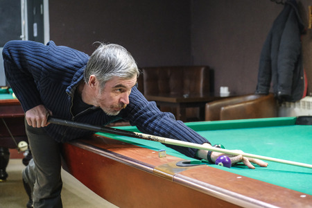 the player takes aim at the ball in Billiards