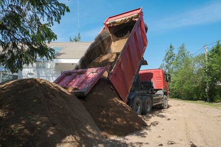the truck pours sand on the construction siteの写真素材
