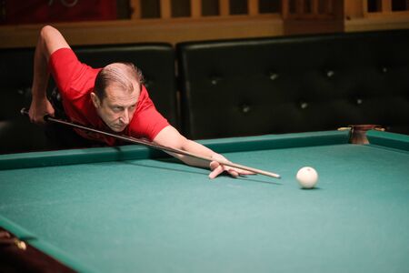 the player takes aim at the ball in Billiardsの写真素材