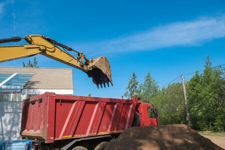 excavator digs clay soil at the construction siteの写真素材