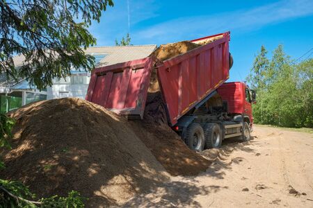 the truck pours sand on the construction siteの写真素材