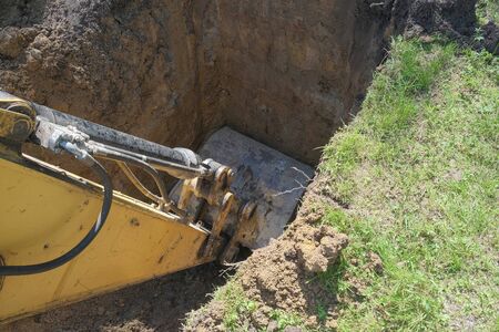 the excavator digs clay soil at the construction site