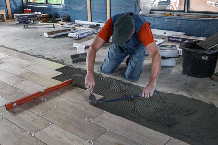 the worker puts ceramic tiles on the construction siteの写真素材