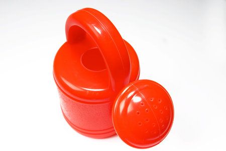 brightly red watering-can on a white backgroundの写真素材