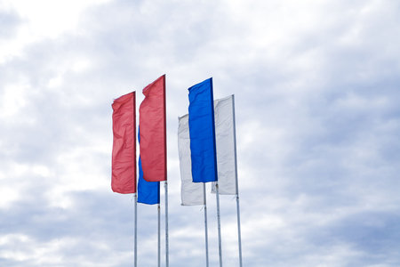 Flags of different colours against the cloudy skyの写真素材