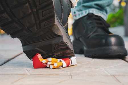 Man decisively crushes a pack of cigarettes.の写真素材