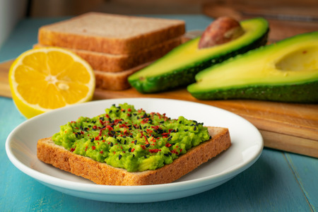 Avocado toast made from bran bread with black sesame and chili pepper.の写真素材