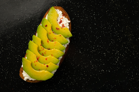 Top view avocado toast with cheese on a black metallic background.の写真素材