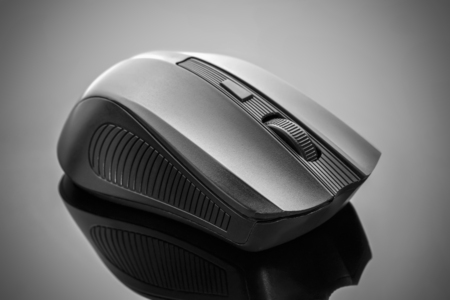 Front view of a black computer mouse on a dark background.の写真素材