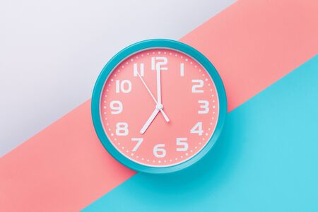 Alarm clock with a round dial on a colored background in the style of material design.の写真素材