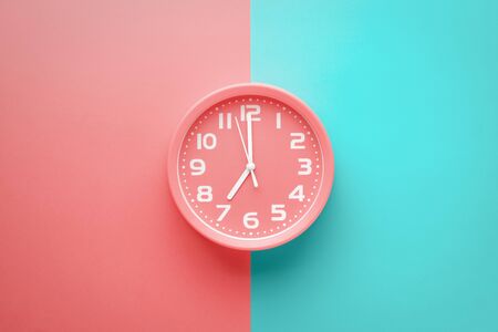 Top view red clock alarm clock not colored background divided vertically into red and green color.の写真素材