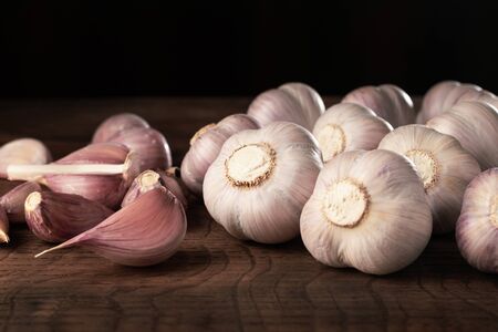 Garlic heads and cloves on wooden table.の写真素材