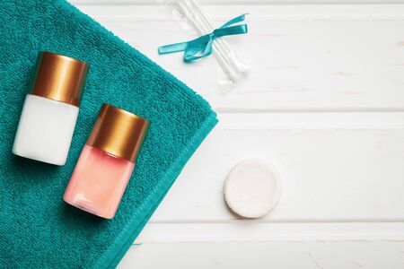 Bottles with shower gel and shampoo as well as soap with cotton buds and a towel as a concept of hotel service.の写真素材