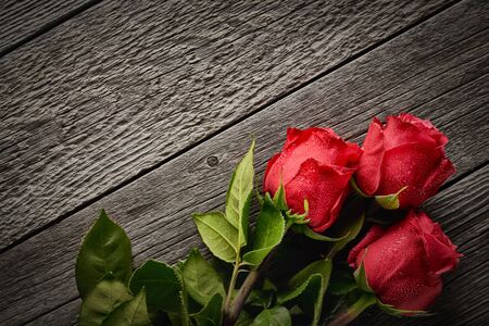 Top view bouquet of beautiful roses on a wooden background with copy space: concept romantic background.の写真素材