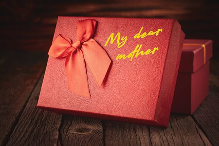 Close up of a red gift box with the inscription "To my dear mom".の写真素材