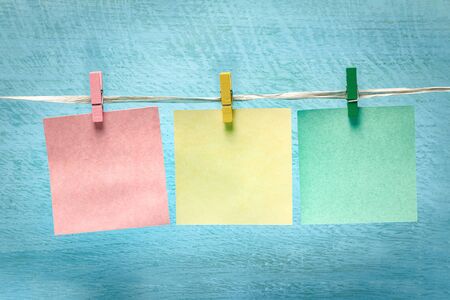 Multi-colored blank notes on a blue wooden board background.
