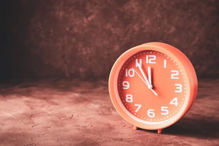 Round clock showing time five minutes to twelve with copy space.