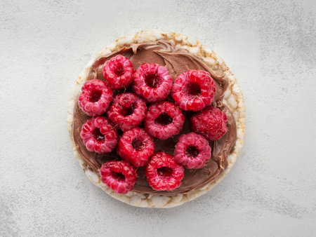 Rice cakes with chocolate nut paste and raspberries top view close up.