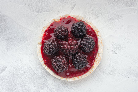 Rice cakes with raspberry jam and blackberries close-up top view.の写真素材