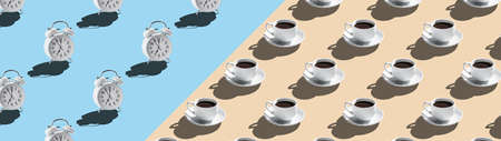 Alarm clock and coffee cups isolated on beige blue background bannerの写真素材